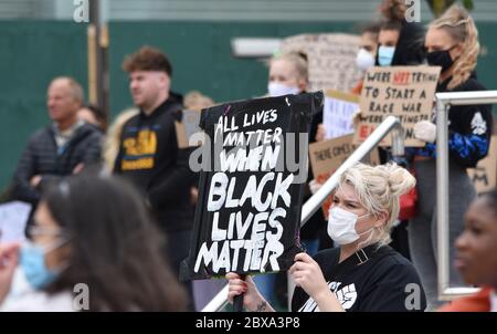 A young blonde caucasian woman protests at a British anti racism rally in the UK holding a sign that reads 'All Lives Matter when Black Lives Matter' Stock Photo