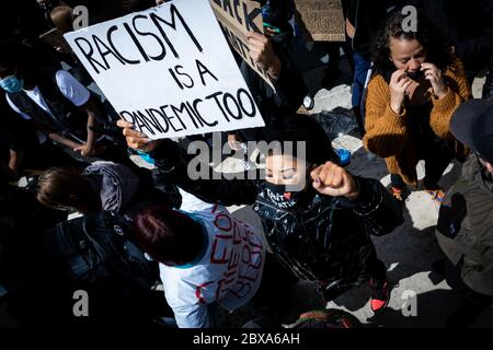 Manchester, UK. 06th June, 2020. A protester holds a placard up with the words 'Racism Is A Pandemic Too', during the protest today which say it coincide with similar Protests all around the world. Credit: Andy Barton/Alamy Live News Stock Photo