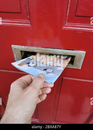 Junk mail being posted through letterbox in the UK Stock Photo