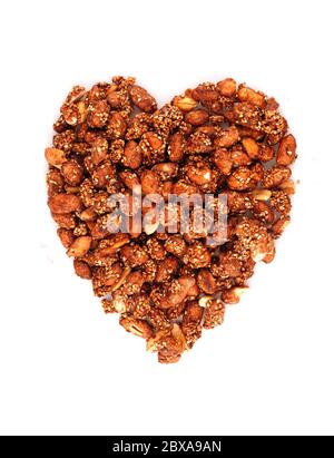 Organic sauce covered peanuts in heart symbol isolated on white background Stock Photo