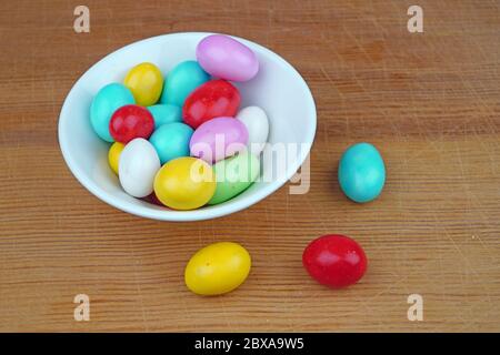 Plateful of Organic almond dragee and Spilled almond dragee on Wooden Background Stock Photo