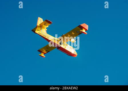 Viareggio, ITALY-JULY 07: Italian Canadair CL-415 known also as Super Scooper is  in flight over tuscanian sky trying to extinguish fire on mountain a Stock Photo