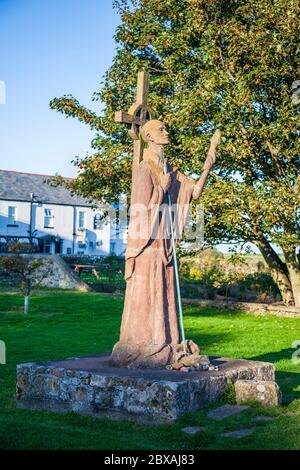 A modern statue of St Aidan of Lindisfarne next to the ruined Priory on Holy Island, Northumberland, England Stock Photo