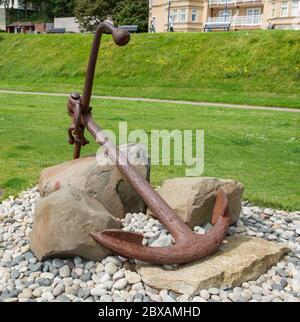 Vintage iron ship's anchor on display on the promenade at Filey in North Yorkshire Stock Photo