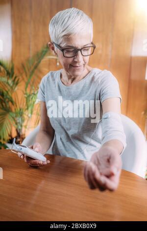 Senior woman doing elbow physical therapy with TENS Stock Photo