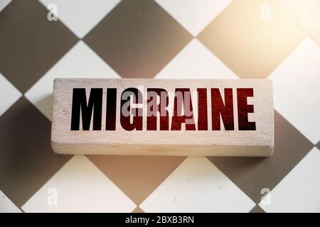 Migraine word written on wood block. Healthcare concept Stock Photo