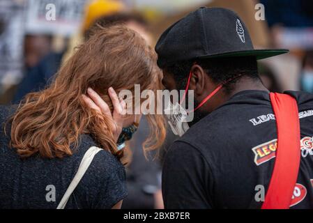 Man and a woman, in face masks, having a conversation (observed from behind), at the Black Lives Matter UK protest. Parliament Square, London, England Stock Photo