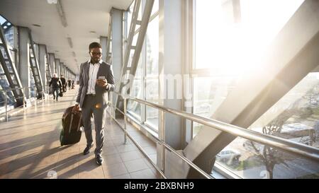 Entrepreneur Man Using Mobile Phone Texting Walking In Airport Terminal Stock Photo