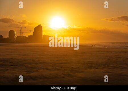 The beach of Oostende (Ostend in English) and its skyline at sunset with strong wind along the North Sea, West Flanders, Belgium. Stock Photo