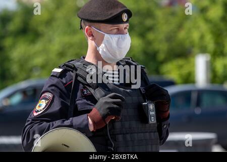 Moscow, Russia. 6th of June, 2020 Close-up view of a police officer wearing a protective mask and gloves while provides security at a public event on Tverskaya street in central Moscow during the COVID-19 coronavirus epidemic in Russia Stock Photo