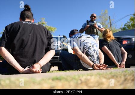 Handcuffed suspects are questioned after they were arrested by U.S. Marshals and local police during the 90-day, multi-state Operation Triple Beam July 23, 2019 in Albuquerque, New Mexico. The operation resulted in more than 6,000 arrests in violence-plagued communities. Stock Photo