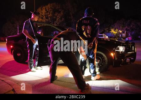 U.S. Marshals and Kansas State police handcuff a suspect arrested during the 90-day, multi-state Operation Triple Beam July 12, 2019 in Wichita, Kansas. The operation resulted in more than 6,000 arrests in violence-plagued communities. Stock Photo