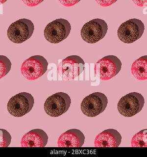 Pink and chocolate donut with sprinkles seamless pattern, sweet glazed dessert food on pink minimal background, top view Stock Photo