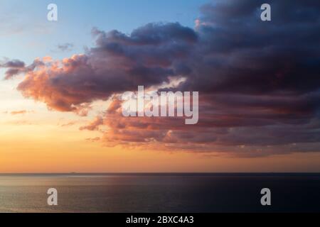 A beautiful sunset seascape and cloudscape with the horizon over water in Batu Ferringhi Beach on Penang Island in Malaysia/ Stock Photo