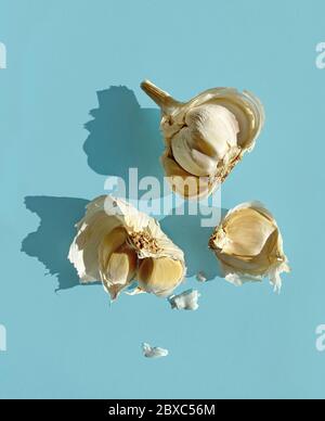 garlic with long shadows isolated on blue background, top view Stock Photo