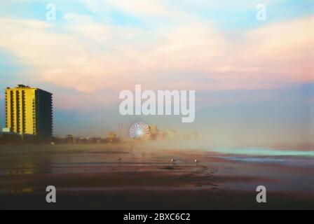 An amusement park can be seen through the thick foggy sunset in the distance at Myrtle Beach South Carolina. Digital Art. Stock Photo