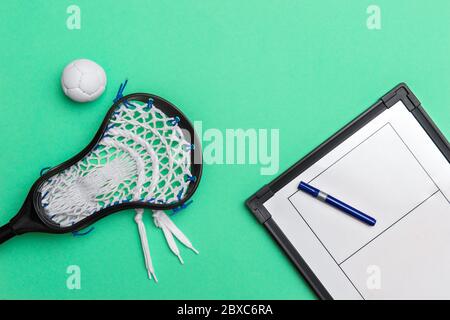 Lacrosse stick, ball and tactical board with marker on green background. Sport  lacross coach concept Stock Photo