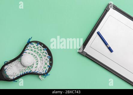 Lacrosse stick, ball and tactical board with marker on green background. Sport  lacross coach concept Stock Photo