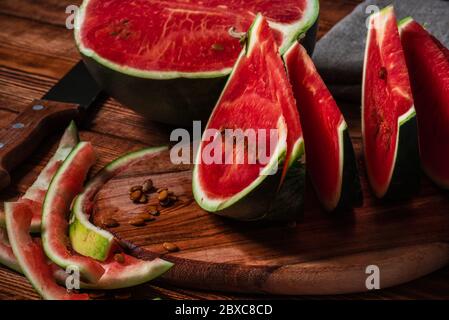 Watermelon slices and peels lying on cutting board Stock Photo