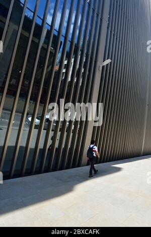 Young Man walking beside 70 St. Mary Axe 'Can of Ham' , City of London, United Kingdom Stock Photo