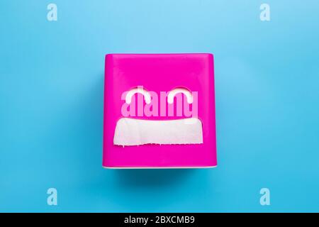 Pink tissue paper box on blue background. Copy space Stock Photo