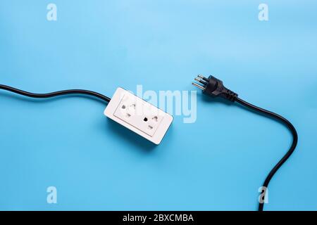 Electrical power strip and plug on blue background. Top view Stock Photo