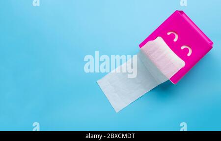 Pink tissue paper box on blue background. Copy space Stock Photo