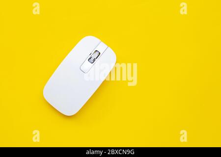 White computer mouse on yellow background. Copy space Stock Photo