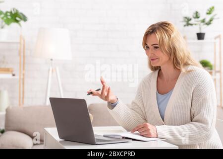 School, college and university online. Smiling female teacher holds lessons on laptop Stock Photo