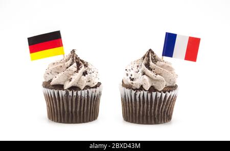 two chocolate swirl cupcakes with German and French toothpick flags isolated on white Stock Photo