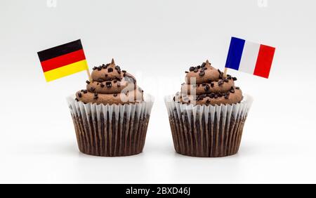 two chocolate swirl cupcakes with German and French toothpick flags isolated on white Stock Photo