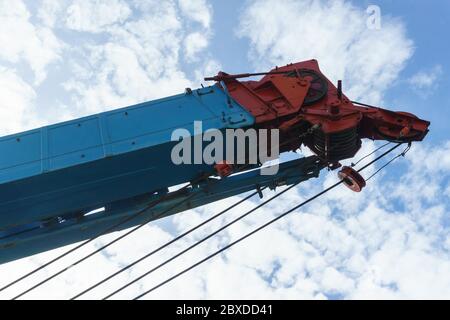 blue red truck crane with hooks and scale weight above blue sky Stock Photo