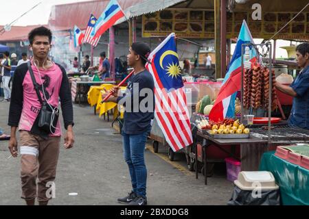 Kota Kinabalu, Sabah, Malaysia - August 07, 2017 : Unidentified are holding a Malaysia flag with a happy face for a decorate stall for Malaysia Nation Stock Photo