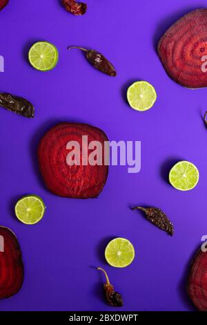 Beetroot in the form of a pattern with lemon slices on a purple background Stock Photo