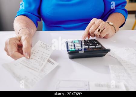 Close-up image of aged woman checking her bills and making calculations Stock Photo