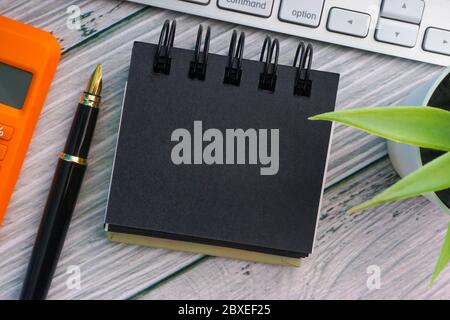 Flat lay and Business Concept.  Fountain pen, keyboard, decorative plant, calculator and notepad on wooden background. Copy space Stock Photo