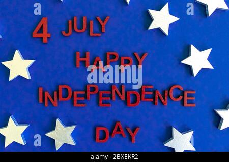 The words 4th July happy Independence Day wooden red letters hand painted for patriotic look. Stars on background. Celebration. Greeting card. Top vie Stock Photo
