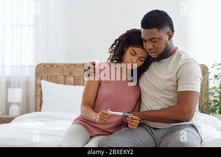 Upset black couple with a negative pregnancy test result Stock Photo