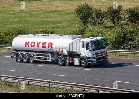 Hoyer Fuel Haulage delivery trucks, HOYER's UK Petrolog fuel tanker articulated lorry, transportation, truck, hazardous cargo carrier, vehicle, MAN European commercial transport industry HGV, M6 at Manchester, UK Stock Photo