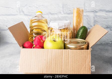 Donation of food collected in a box. Gray background. Copy space Stock Photo