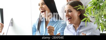 Small team employees emotionally watching events. Stock Photo