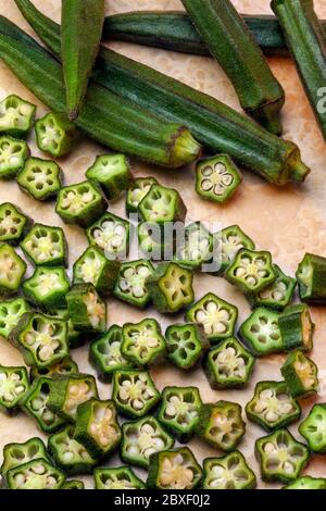 Okra is a plant of the mallow family with long ridged seed pods, native to the old world tropics. Also known as ladies fingers, bhindi, bamia, or gumb Stock Photo