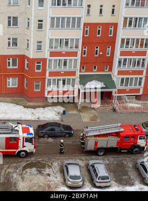 Fire engine in the courtyard of a multi-storey residential building in winter. Stock Photo