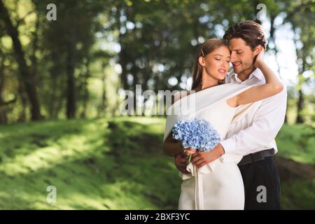 Loving Couple Hugging Standing In Beautiful Forest Having Minimalistic Ceremony Stock Photo