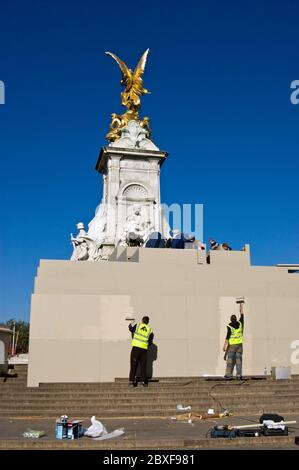 London, UK - April 27, 2011:  Workmen painting a hoarding around the Victoria Memorial outside Buckingham Palace ahead of the Royal Wedding of Prince Stock Photo