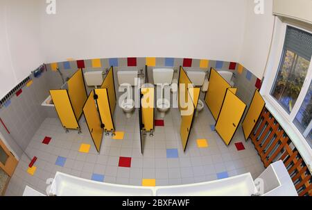interior of the wide bathroom of a kindergarten without children with yellow doors photographed with fisheye lens Stock Photo