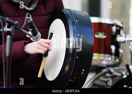 Woman plays on big acoustic drum, closeup Stock Photo