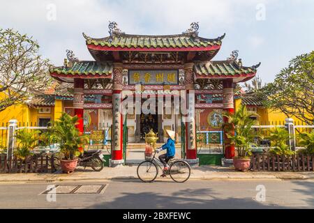 HOI AN, VIETNAM - 25TH MARCH 2017: The outside of the Trieu Chau Assembly Hall in Hoi An, Vietnam during the day. A person with a traditional conical Stock Photo