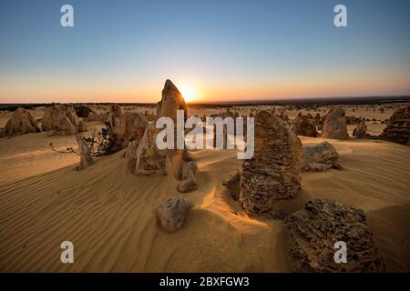 Sun setting behind the limestone stacks in the Pinnacles desert in the Nambung national park located north of Perth in Western Australia Stock Photo