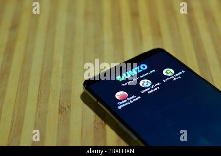 Mumbai, India, 2020. Dunzo Delivery app logo glowing on the mobile phone screen. Selective focus and shallow depth of field. The main focus is on the Stock Photo